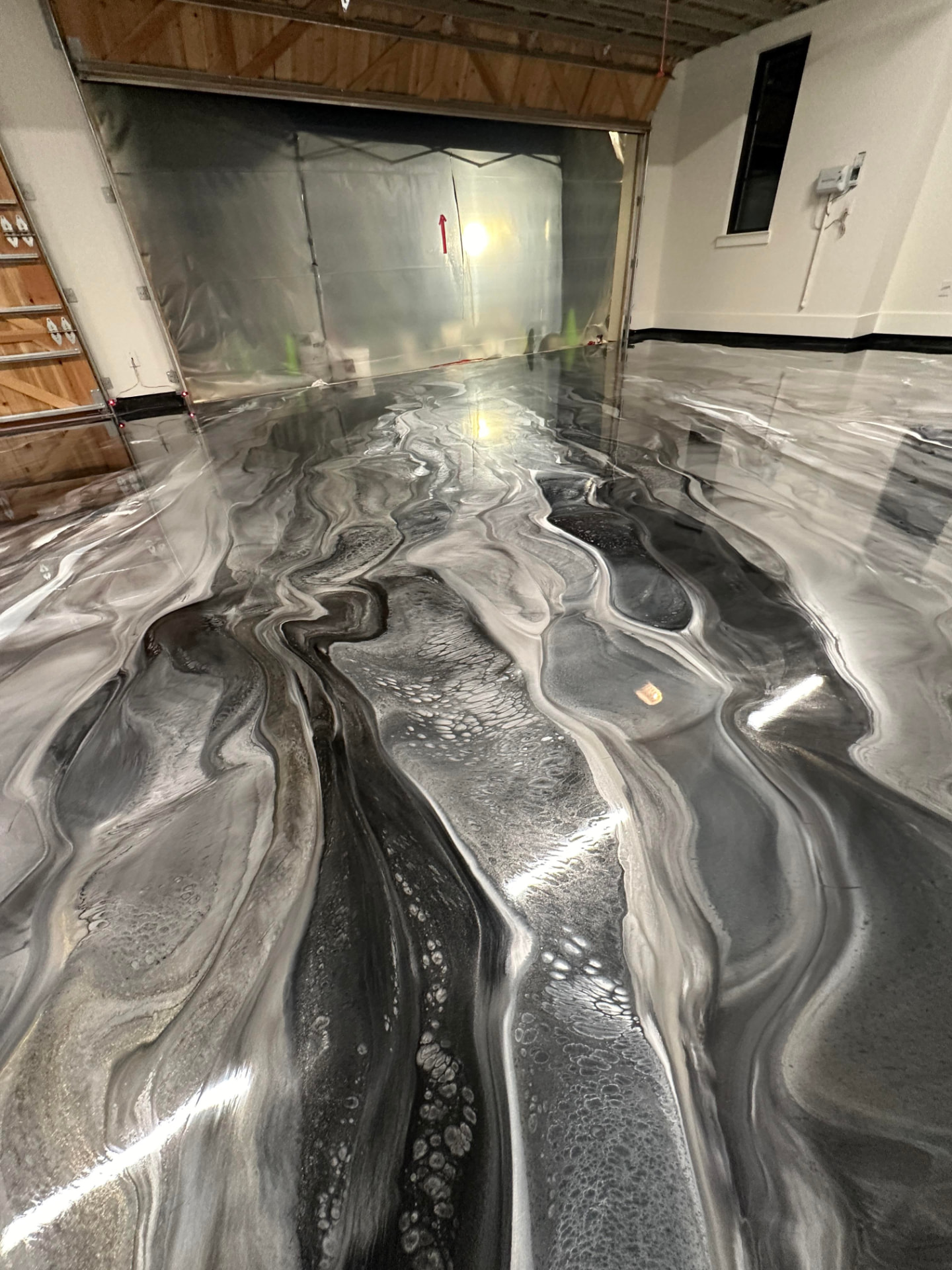 Charcoal and silver metallic epoxy garage floor with flowing swirl pattern